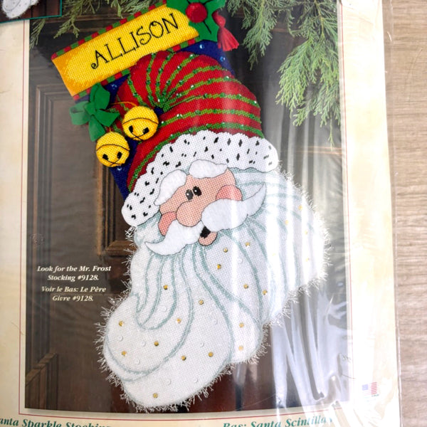 Decorative stocking with a Santa Claus design and 'Allison' on top, against a wooden background.