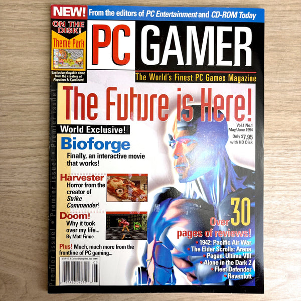 PC Gamer magazine cover with gaming-themed text and graphics on a wooden surface