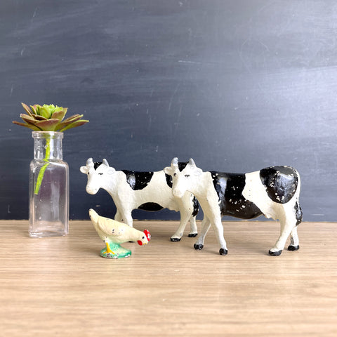 Metal cow figurines and a chicken - vintage Holstein pair and a fowl