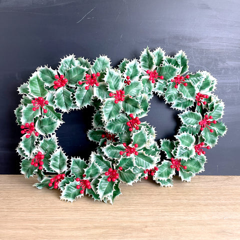 pair of 1960s vintage green and white holly plastic christmas wreathes with red holly berries.